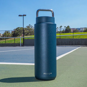 Insulated dark blue travel mug with stainless steel carrying handle, part of Fellow, Take away, Latest news, all about coffee.