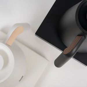 Close-up of black and white electric kettle with wood details for barista and brew accessories from Timemore