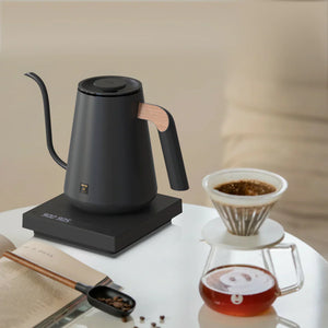 Black electric kettle with wooden detail on the handle and narrow spout for barista and brew accessories all about coffee.