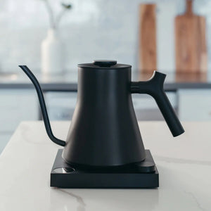 Black electric kettle with a narrow gooseneck on the base unit, part of Fellow, Kettle, EspressoGear, all about coffee.
