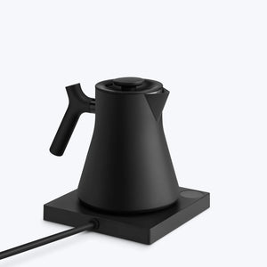Matte black kettle with ergonomic handle on warming plate, part of Fellow, EspressoGear, all about coffee