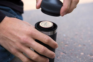 Close-up of hand inserting capsule adapter into Portable coffee maker, barista and espresso category.