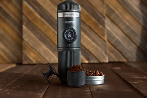 Black portable Nanopresso with coffee capsules and ground coffee, espresso accessories from Barista, and portable coffee makers.